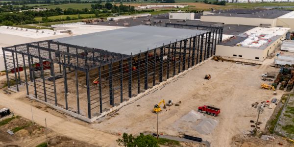 A large industrial building under construction with steel framework.