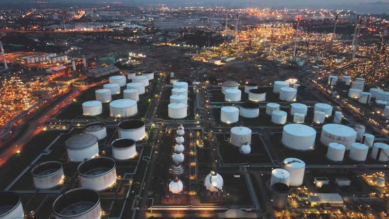 aerial showcasing large storage tanks and fuel infrastructure in a fully lit industrial energy complex. relevant to oil logistics, energy exports, and infrastructure-heavy investment visuals.
