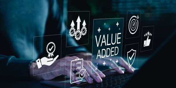 Hands typing on a laptop with value added business icons overlay.