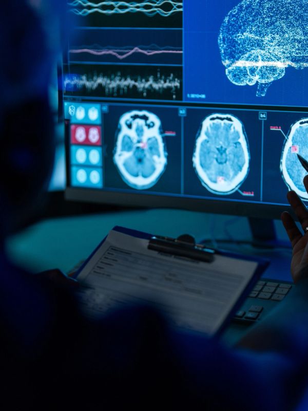 Doctor analyzing brain scans on computer screen.