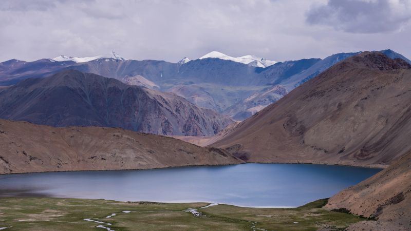View of Ladakh showcases beauty Himalayan highlands vehicle foreground road emphasizes Ladakh’s unique of one of India’s most remote and stunning regions.
