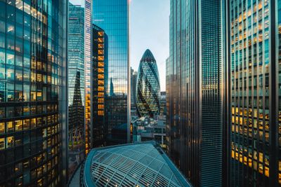 Modern skyscrapers in a city reflecting the sunset light.
