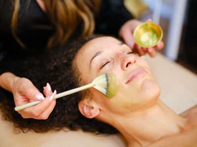 Woman receiving a facial mask treatment.