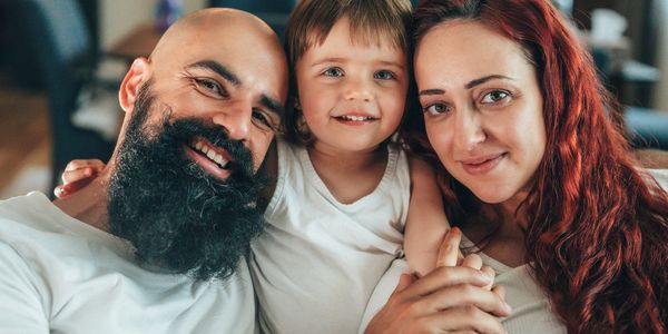 Happy family portrait with smiling parents and child indoors.