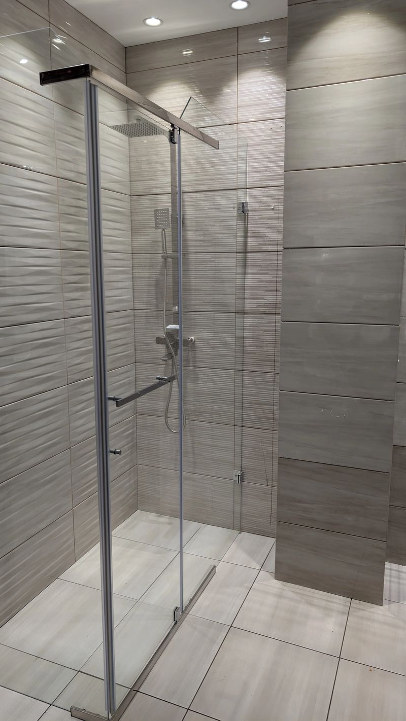 This stylish glass shower with contemporary tile design elevates modern bathrooms with elegance and comfort