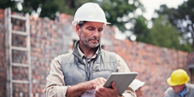 Construction worker using a tablet on site.