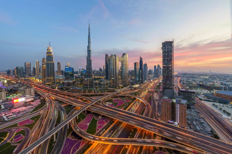 A stunning view of Dubai's skyline and a bustling highway captured at sunset, showcasing urban life in the United Arab Emirates.