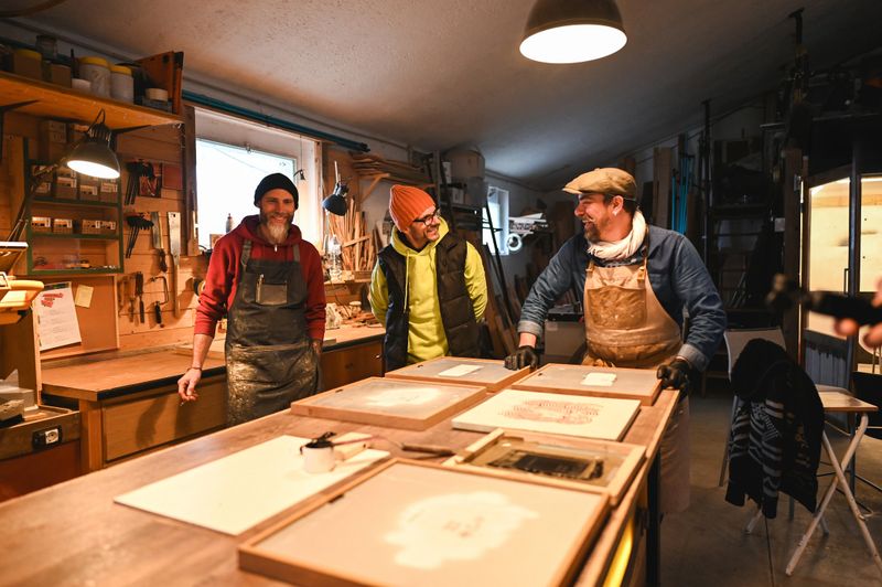Carpenters showing woodworking projects in workshop