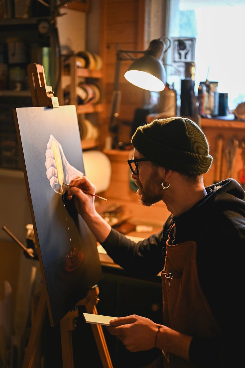 Artist painting on canvas in his workshop under warm light