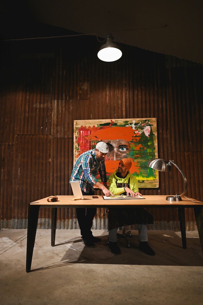 Two artists collaborating on a project in their rustic studio