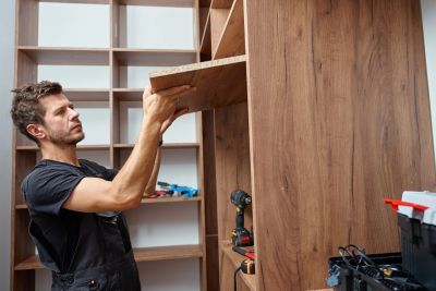Man assembling wooden shelves.