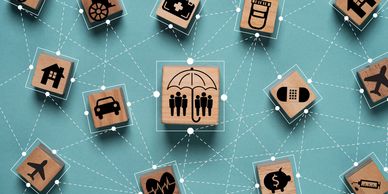 Wooden blocks with insurance-related icons connected by dotted lines.