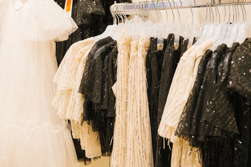 Elegant white and black sequined dresses on display in a fashion boutique.