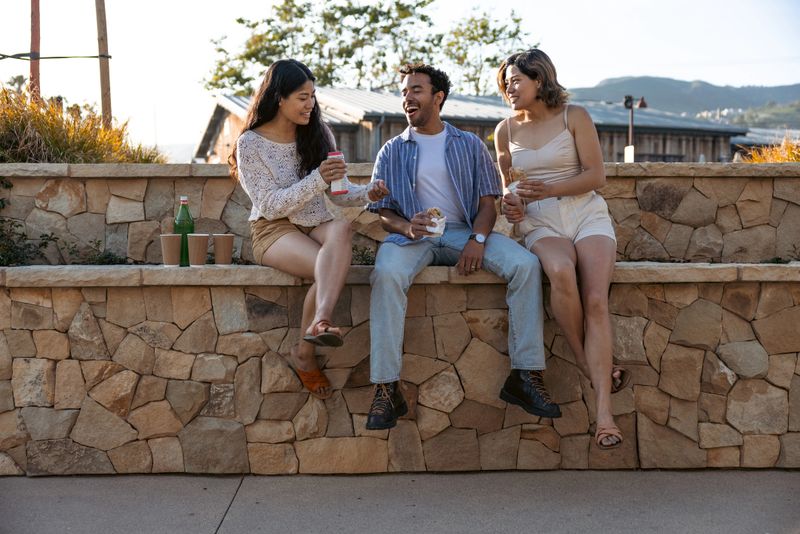 Three friends eating a sandwich together.
