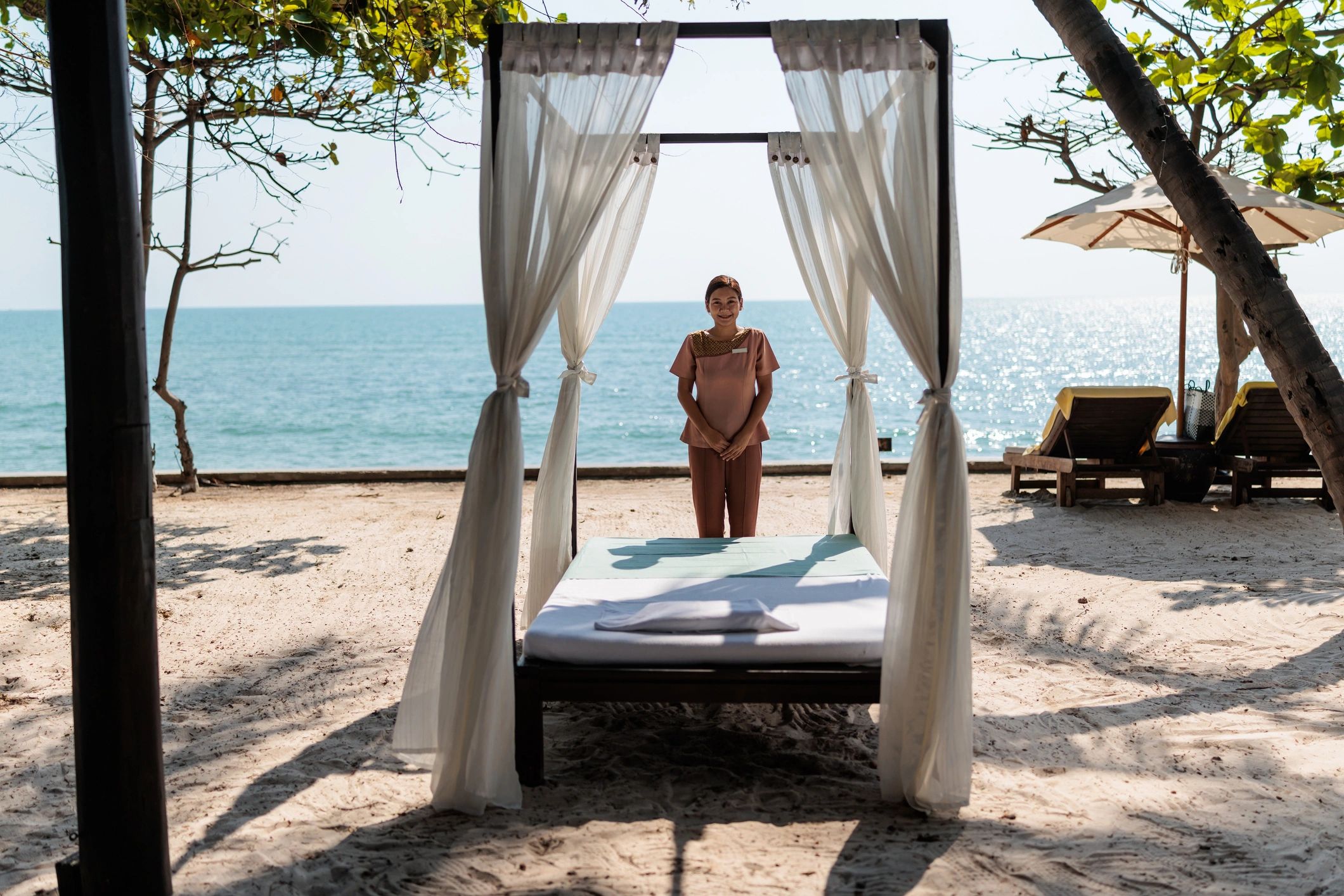 Woman enjoying a relaxing massage with candles and a flower in her hair.