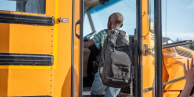 A child boarding a yellow school bus.