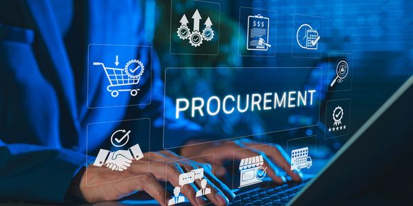Business professional typing on laptop with procurement-related icons floating above the keyboard.