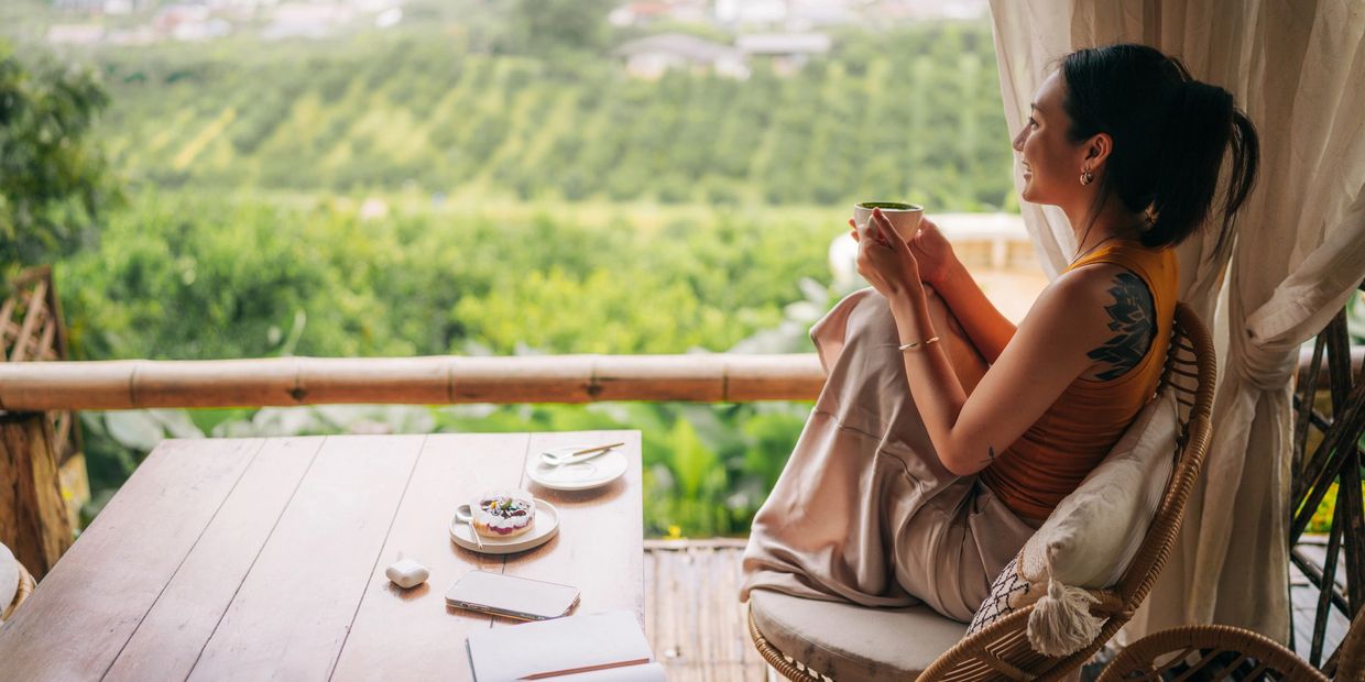 A group meditation session outdoors on a wooden deck.