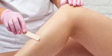 Person applying wax for leg hair removal.