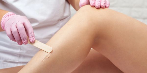Person applying wax for leg hair removal.