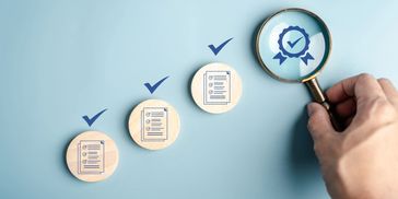 Magnifying glass focusing on a quality badge with checklist icons and checkmarks.