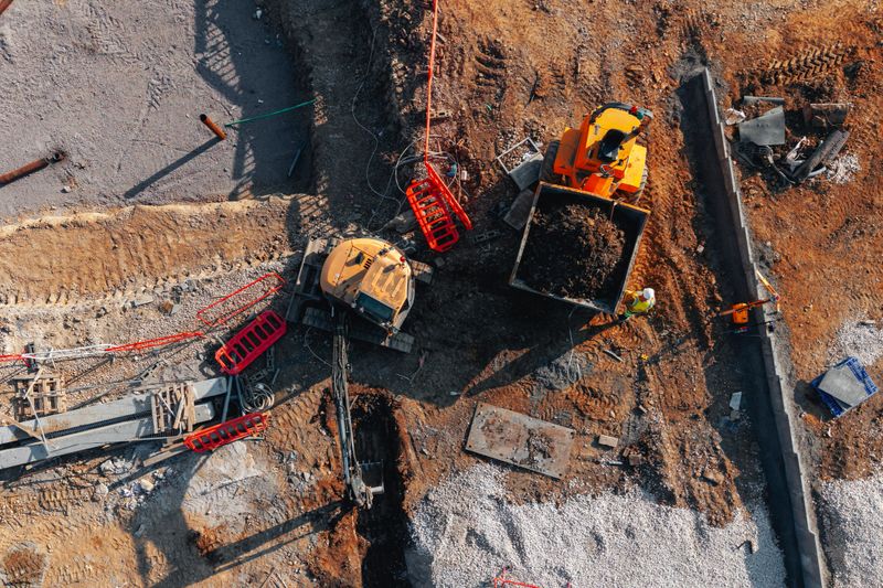 Aerial view from drone at excavator and dumper busy at construction site