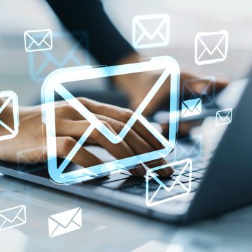 Hands on a laptop with floating email icon images