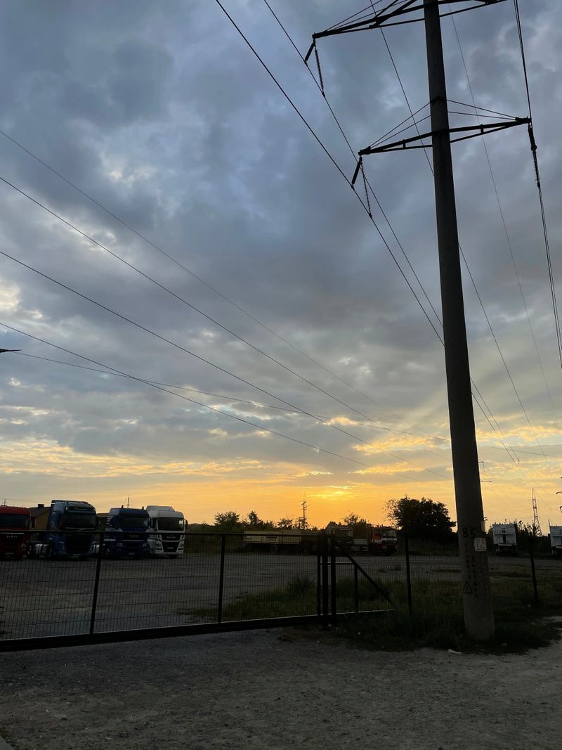 Trucks lined up under a colorful sunset sky