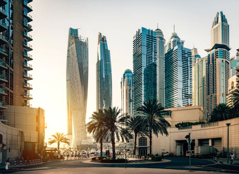 Modern Skyline of Dubai Marina Skyscraper at dusk with Sunlight Reflecting on Waterfront Buildings