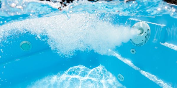 Bubbles rising underwater from pool jets.