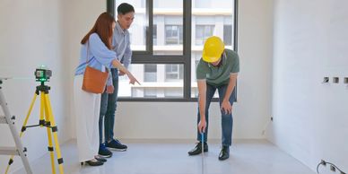 Couple inspecting apartment with construction worker.