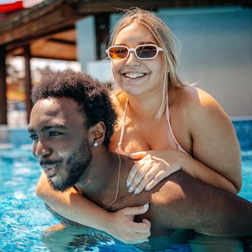 happy couple swimming in clean pool