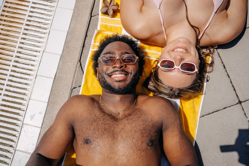 People enjoying at swimming pool in the water on warm sunny day