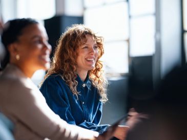 Two women smiling while working together.