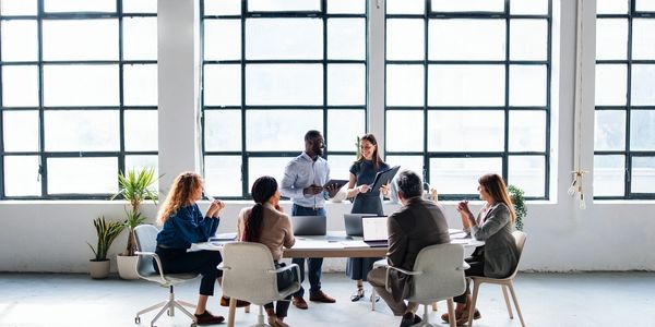 Team collaborating and discussing ideas in a modern office meeting.