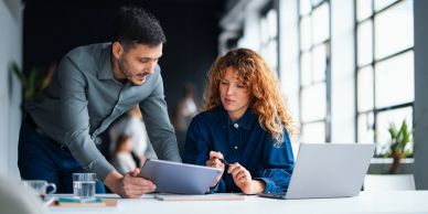 Man shows tablet to woman at work.