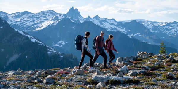 Three hikers trekking in snowy mountains.