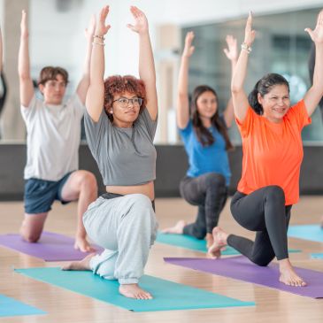 Group yoga class with participants stretching.