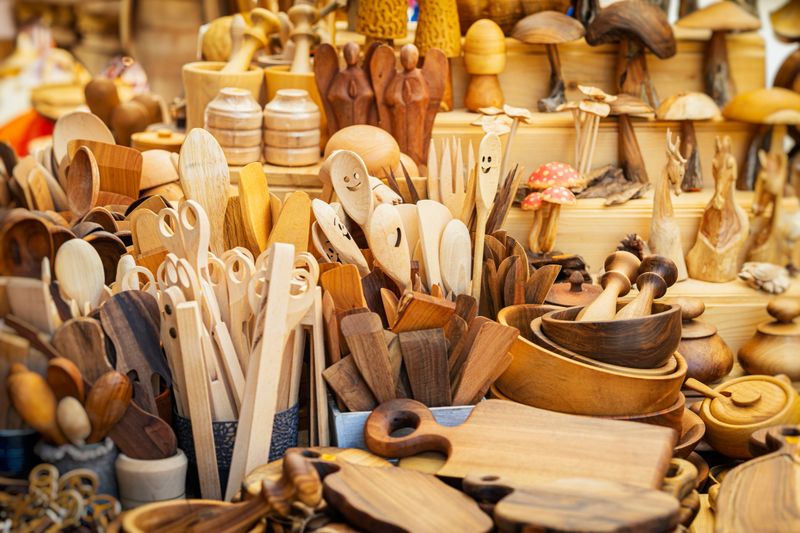 Kitchen wooden utensils. Variety of handcrafted wooden kitchen utensils and decor items displayed at artisan market. Concept of wooden crafts, sustainable kitchenware and eco friendly design