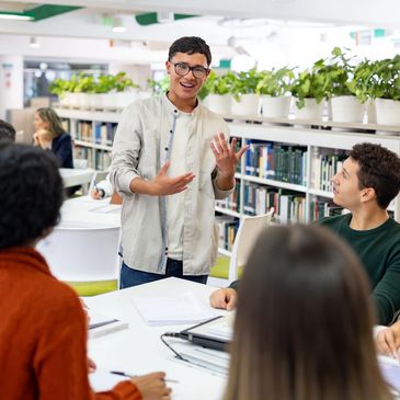 Student presenting to a group in a library setting.