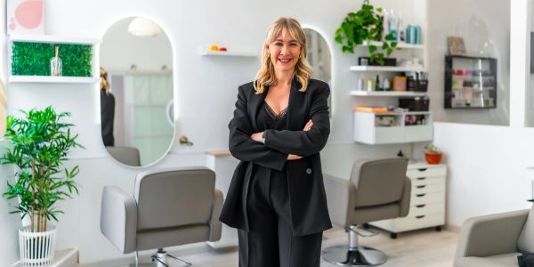 Smiling woman standing in a modern hair salon.