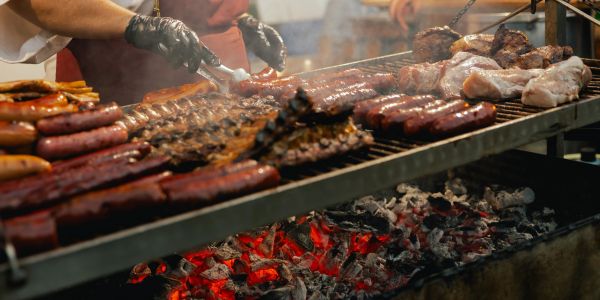 Grilling various meats over hot coals.