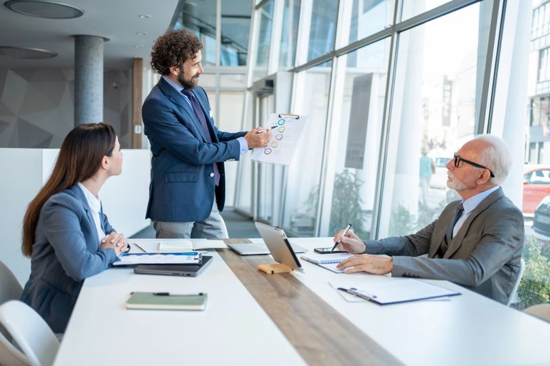 Business team discussing financial charts and graphs during a meeting in a modern office, collaborating on important data analysis for strategic decision-making