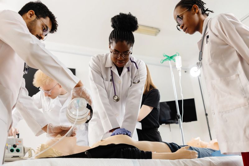 Healthcare professionals practicing cpr and iv insertion during medical training on anatomical model