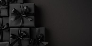 Elegant black gift boxes with ribbons on a black background.