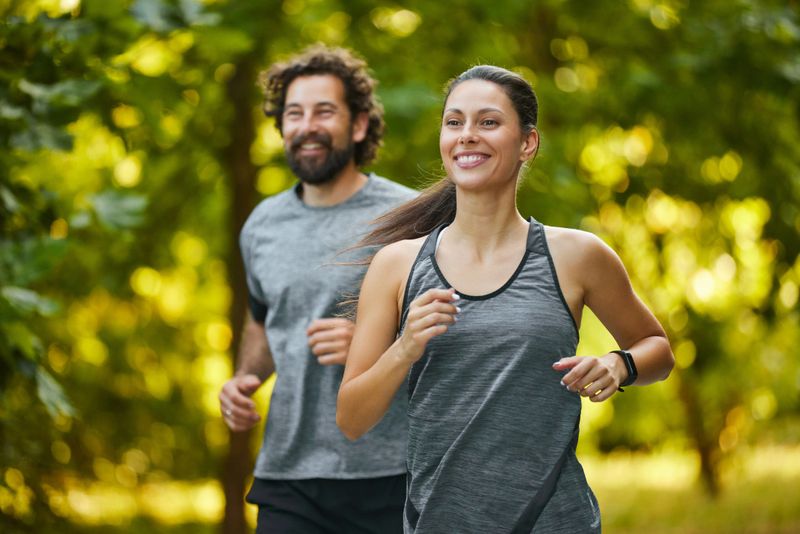Young couple jogging in the woods, enjoying a healthy lifestyle