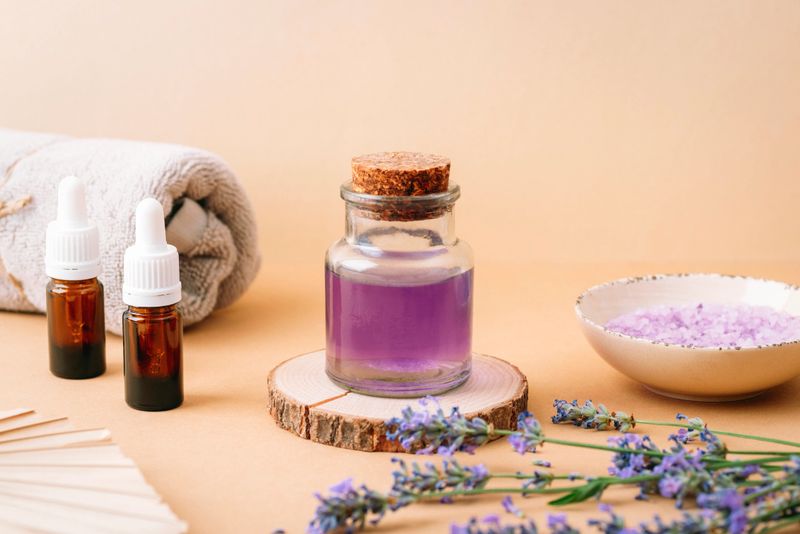 Lavender oil, bath salt and towel for spa treatment on beige background. Aromatherapy concept.
