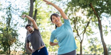 Two people stretching outdoors in a park.