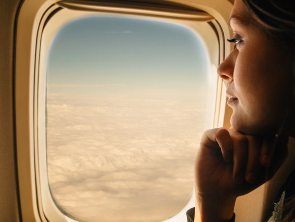Woman looking out of an airplane window.