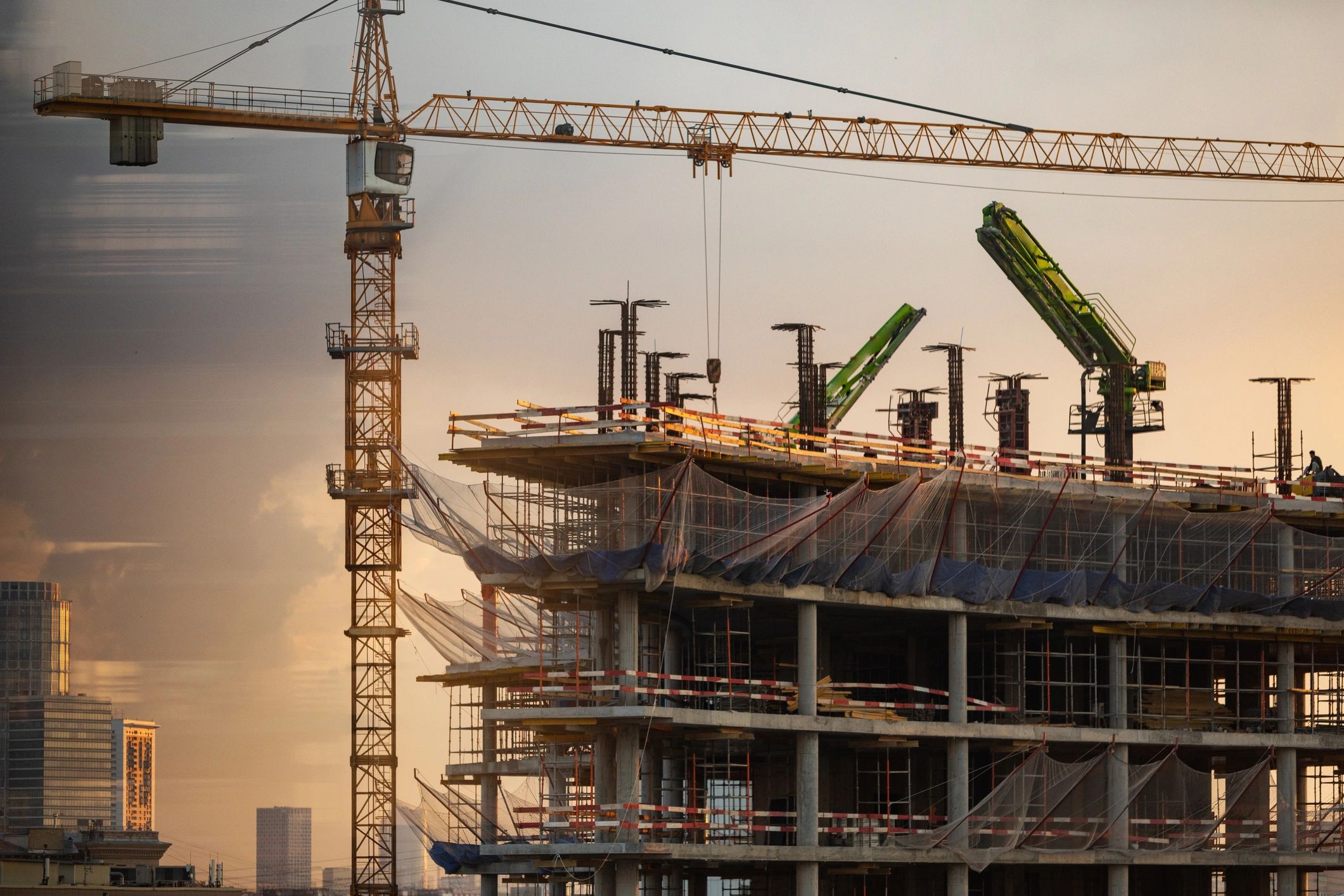 Construction site with crane at sunset.